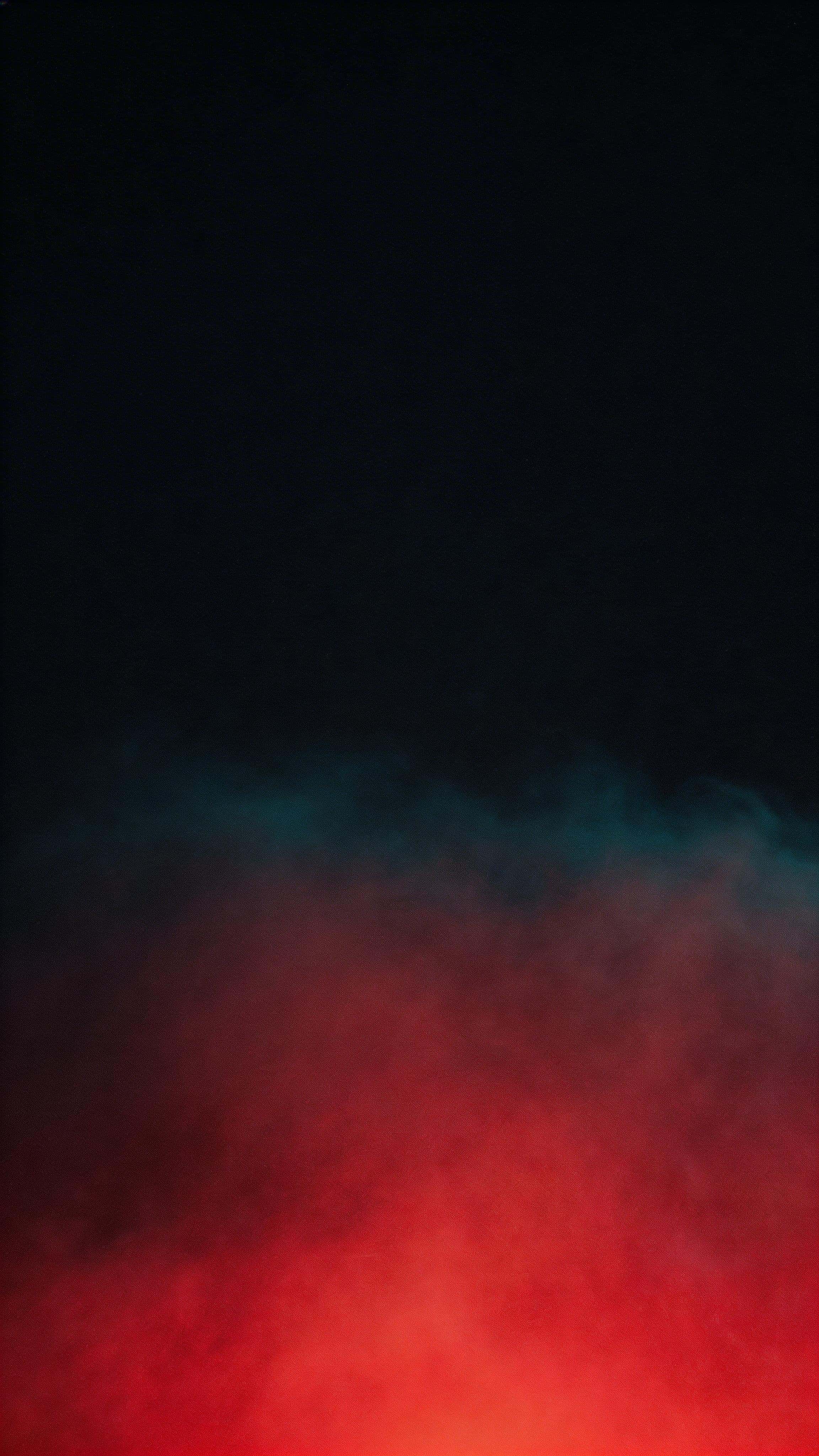 9:16 vertical wallpaper of subtle red gel-lit fog rising from the lower third into deep navy-black negative space, with a cyan-teal fringe, soft bloom, and fine film grain.