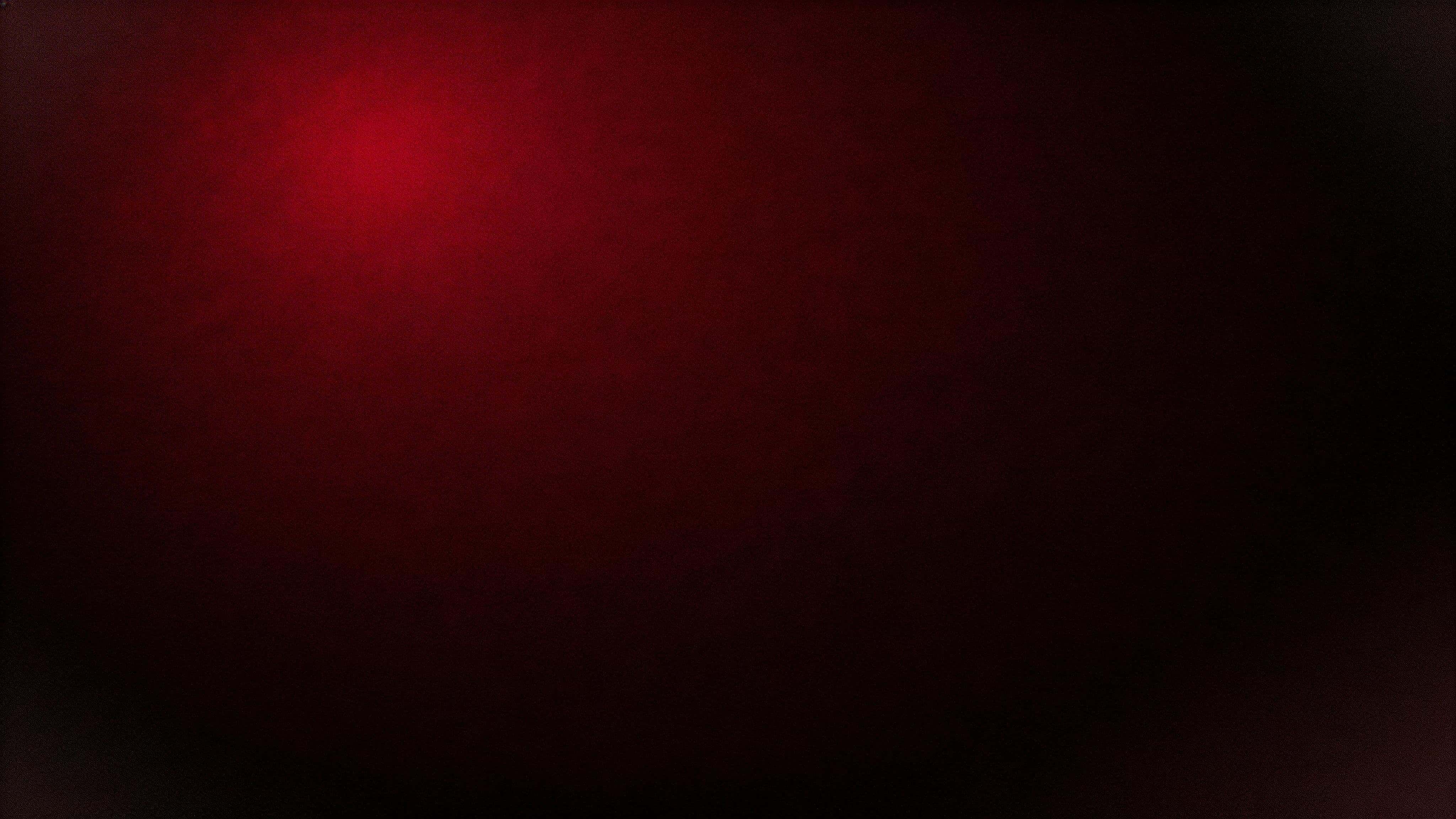 Minimalist 16:9 widescreen abstract gradient photograph of deep crimson fading smoothly into near-black with an off-center low-brightness crimson, wide negative space, subtle vignette and film grain.