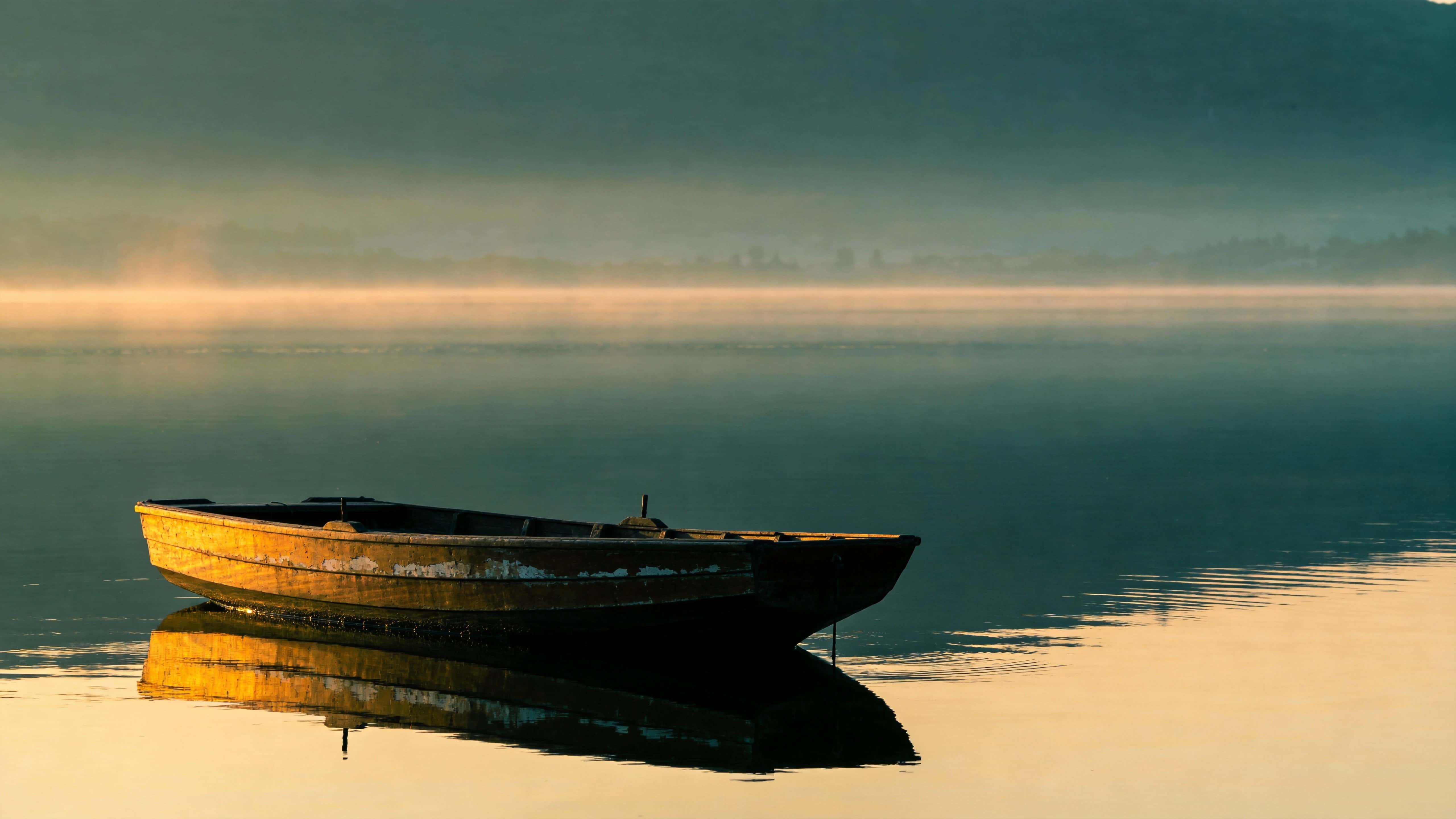 A single boat rests on utterly calm water in a fine-art photographic study with soft golden-hour light and reflected symmetry, composed for 16:9 display.
