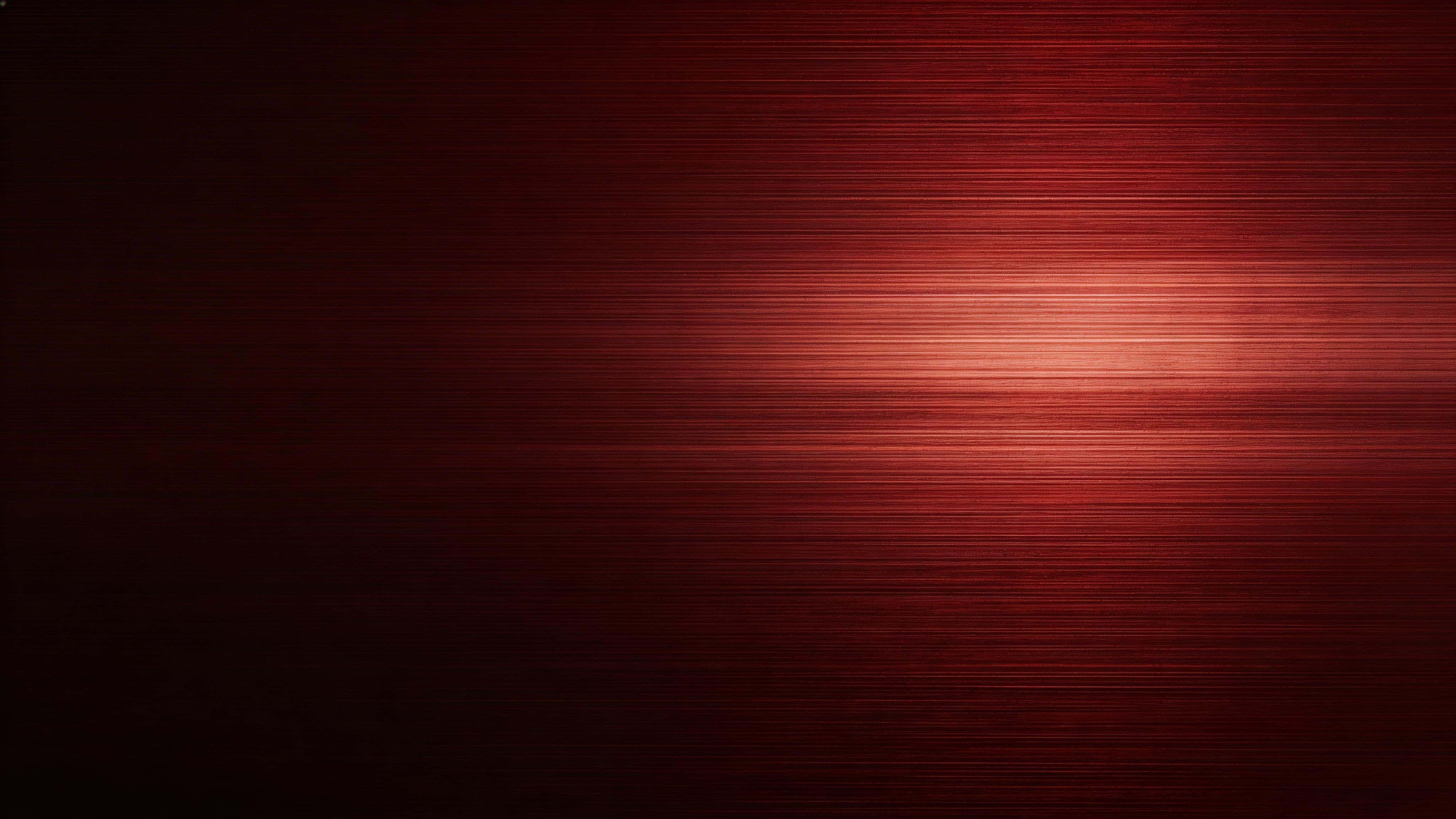Widescreen 16:9 wallpaper of brushed red metal as a luxury product backdrop with steady grain, a soft off-center highlight band, deep maroon valleys and near-black edges reserved for icons.