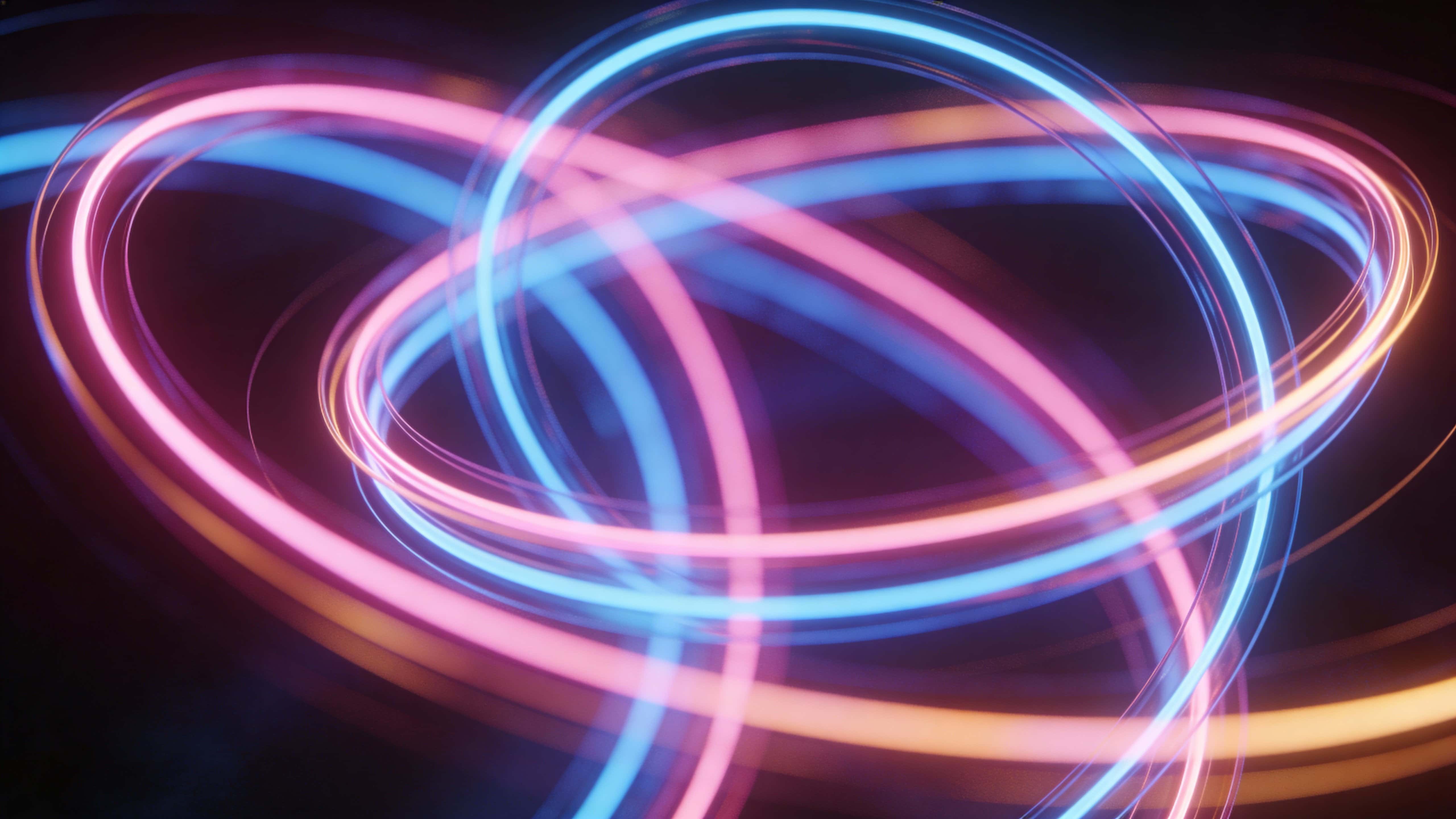 Glossy neon ribbons of pink, blue, and amber twist and layer through a dark, atmospheric 16:9 frame around an invisible core, creating elegant, dynamic depth.