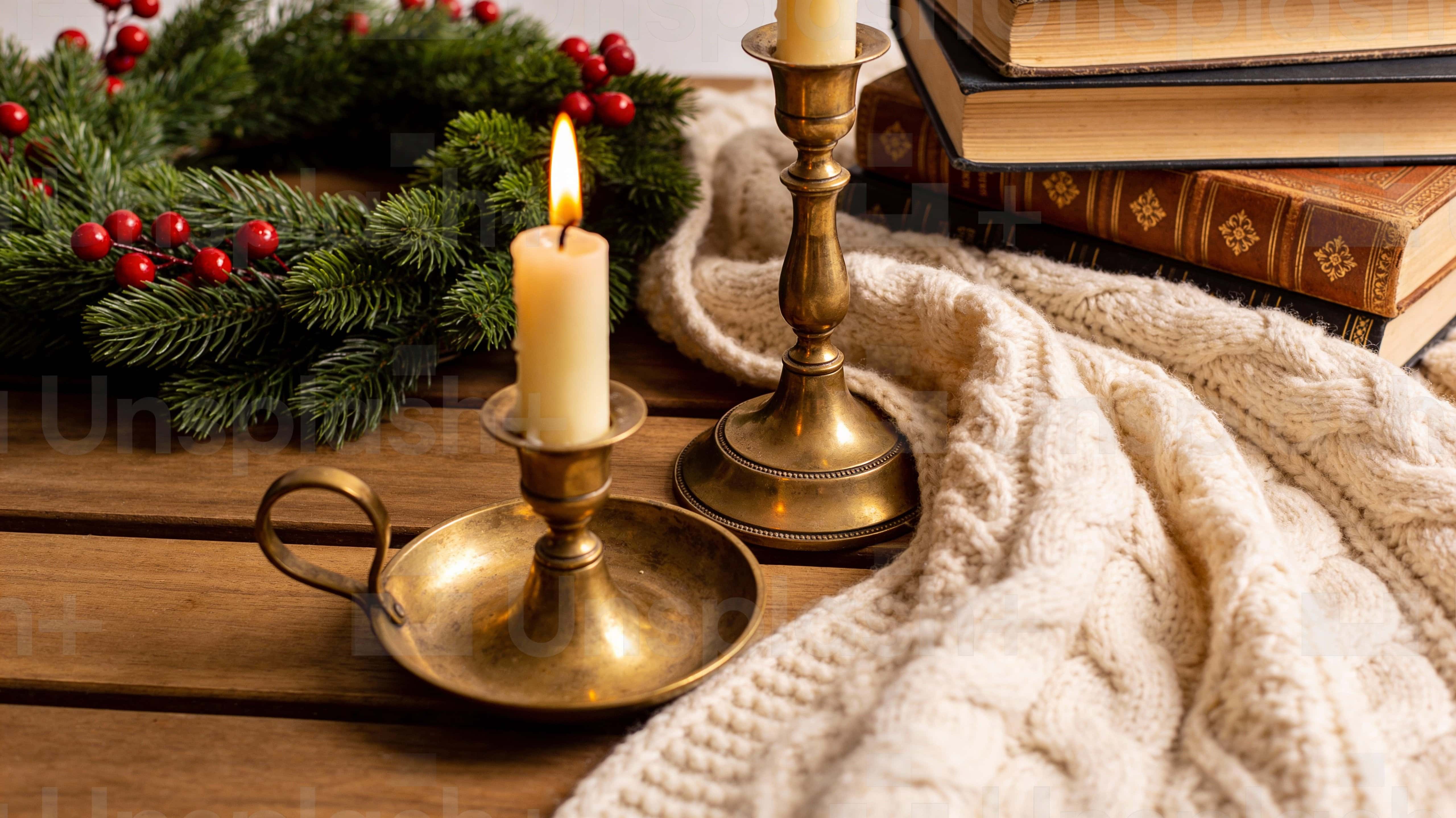A luxury rustic holiday table vignette with pine sprigs, ornaments and wrapped gifts arranged on warm wood and linen, softly even-lit and framed in a 16:9 advertising-ready composition.
