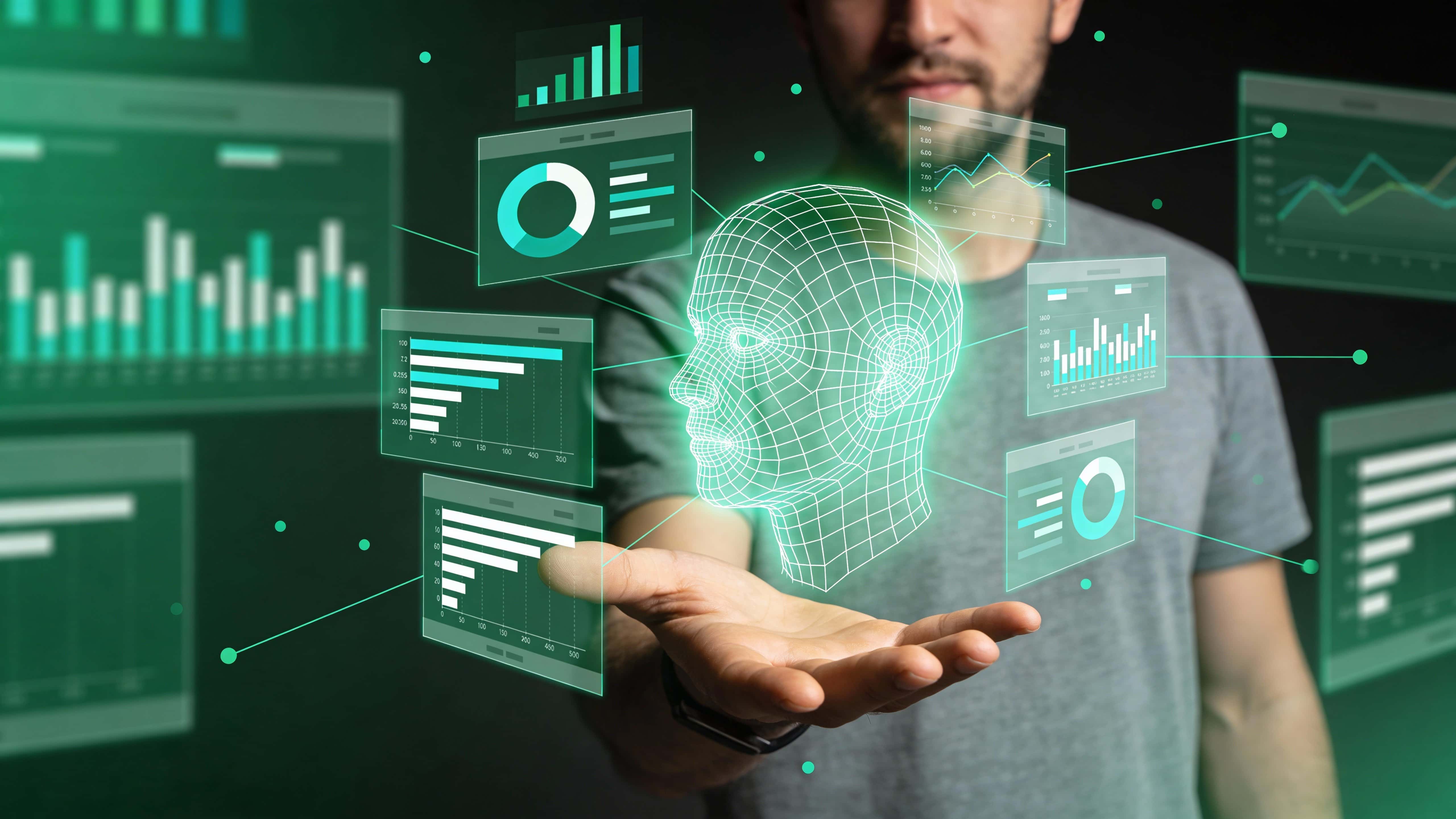 A glowing digital human head of thin grid lines hovers above a man's open palm, surrounded by semi-transparent data dashboards and metrics, set against a dark blurred background.