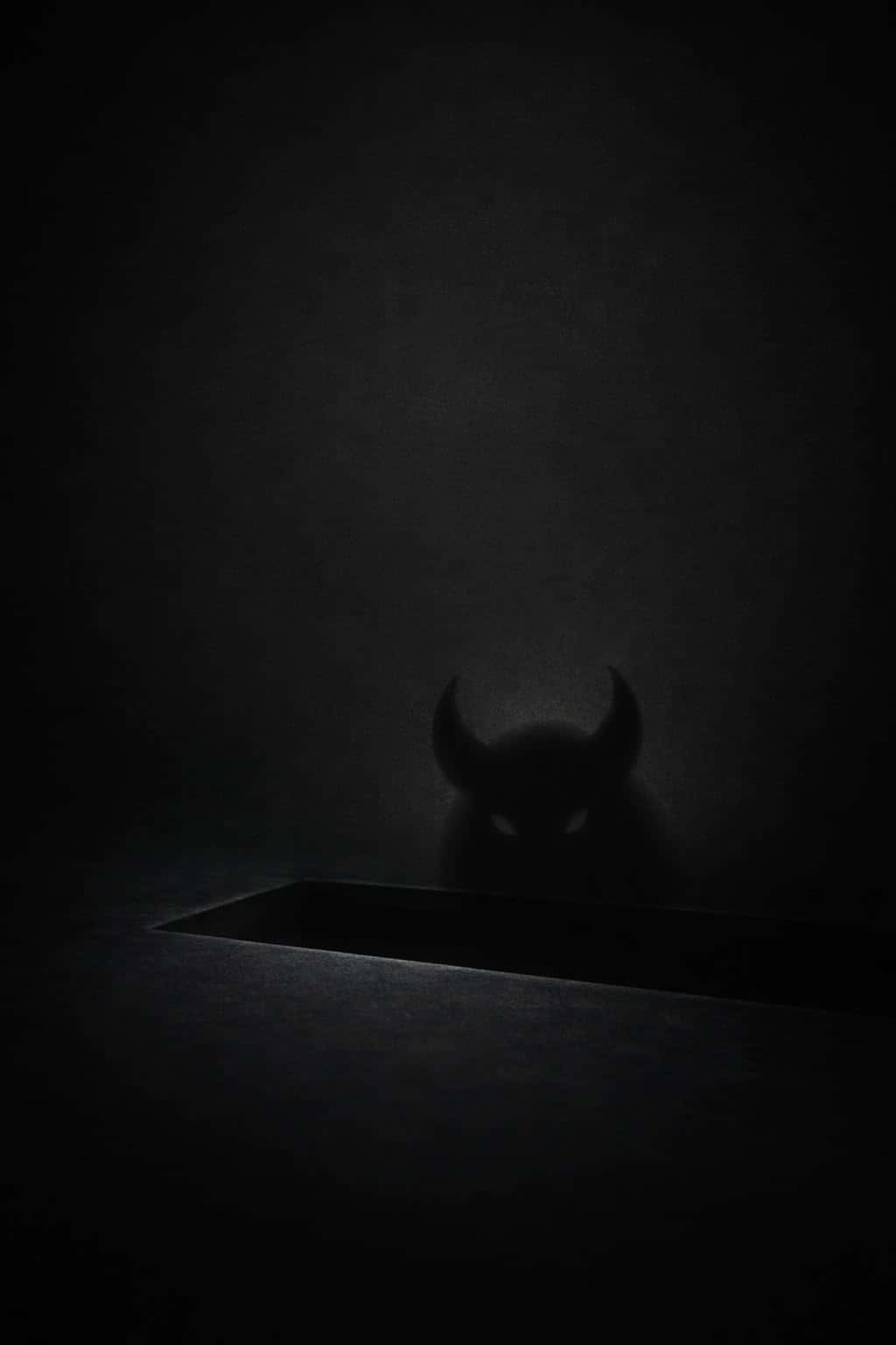 Horned sprite silhouette hinted through a faintly lit bevel on a minimal charcoal background with subtle grain and soft vignette, lower third left of center, clean surfaces.