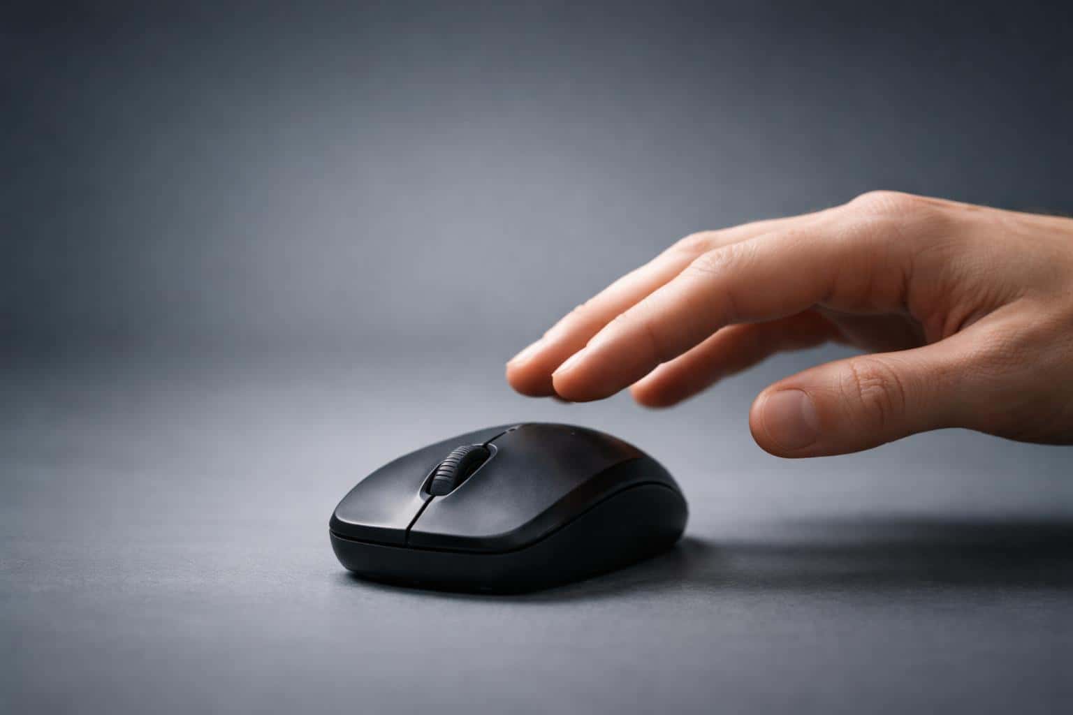 Close-up product photograph of a human hand hovering above a computer mouse with shallow depth of field and explicit 3:2 composition guidance for a poster-cover use.