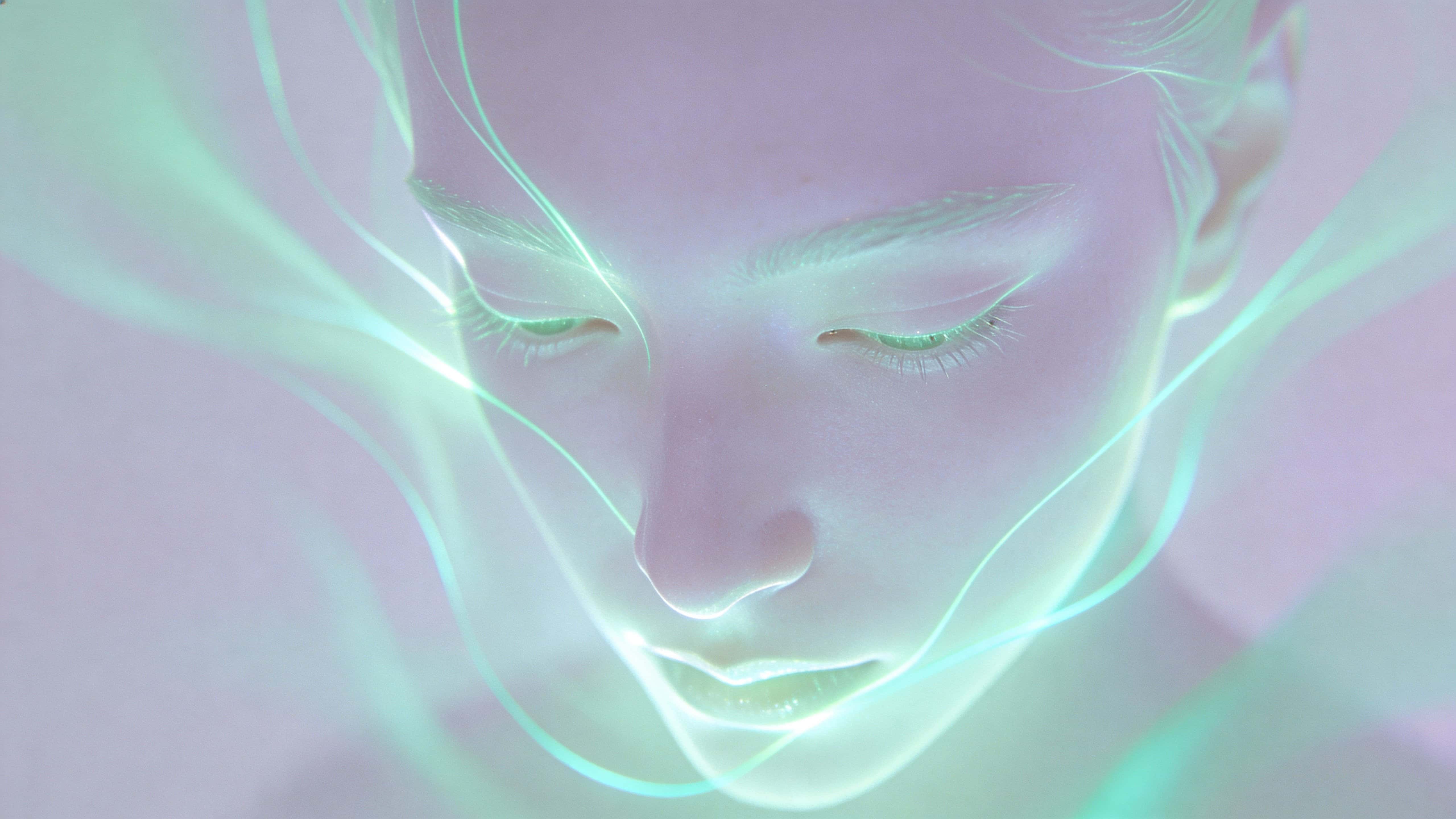 A pale lavender face wrapped in flowing contour lines glowing mint green and soft aqua that drift gently from forehead to chin, centered in a 16:9 frame with a minimal desaturated background.
