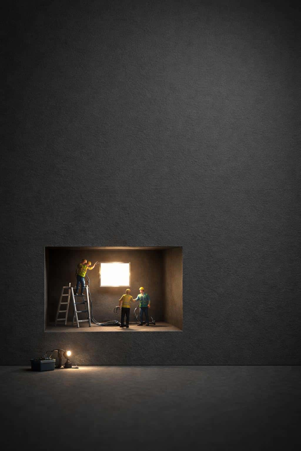Portrait 2:3 scene of a matte charcoal panel with fine grain and soft vignette, lower-third recessed cutout revealing tiny 3D workers installing a warm glowing panel.