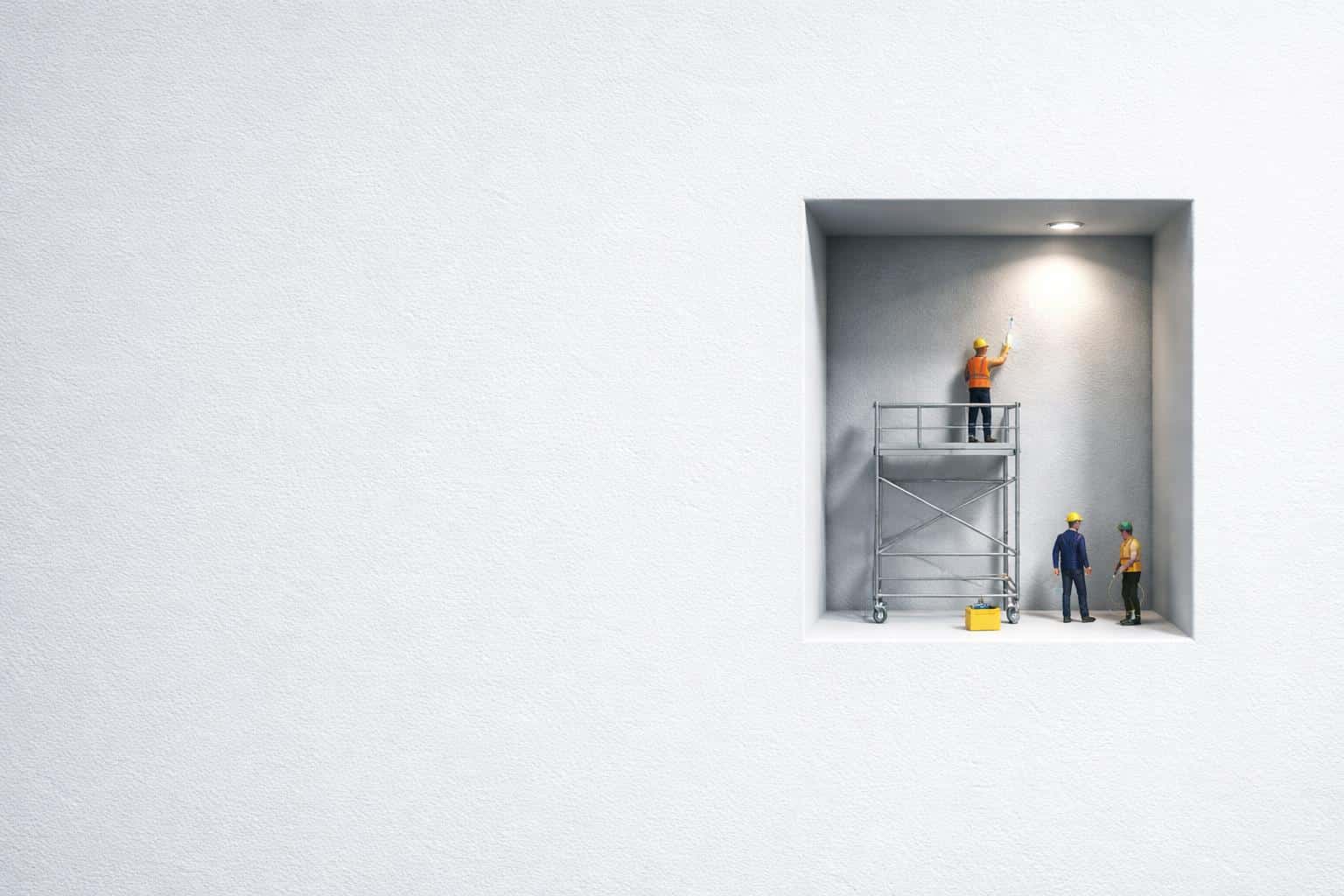 3:2 scene with pale blue-gray textured negative space left and a right recessed cutout where a tiny crew polishes a glossy patch inside, scaffold and crate visible.