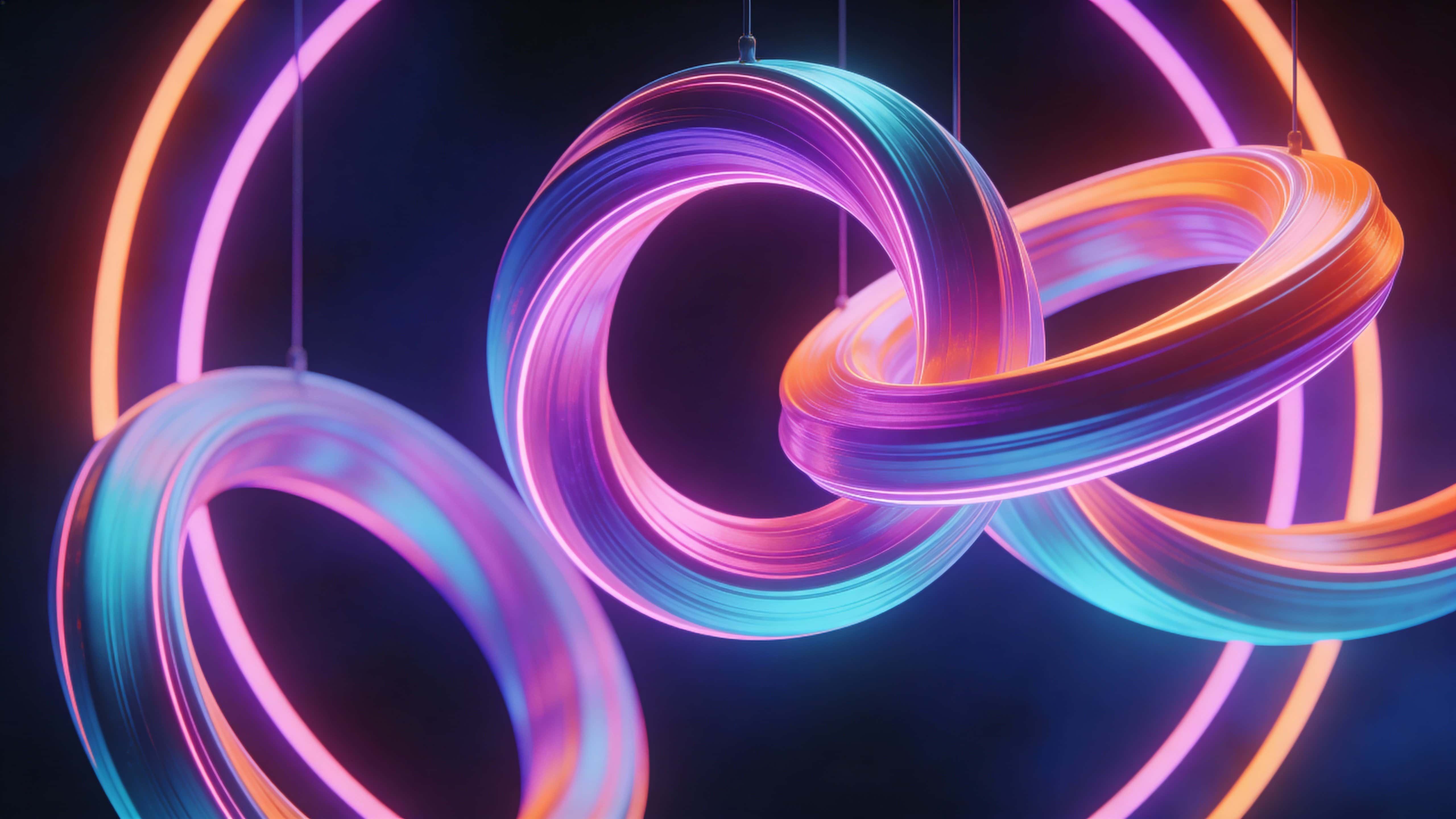 A 16:9 framed abstract neon sculpture of flowing circular light bands in pink, violet, cyan, and orange, twisting and overlapping against a minimal deep-blue and purple backdrop with soft halo glow.