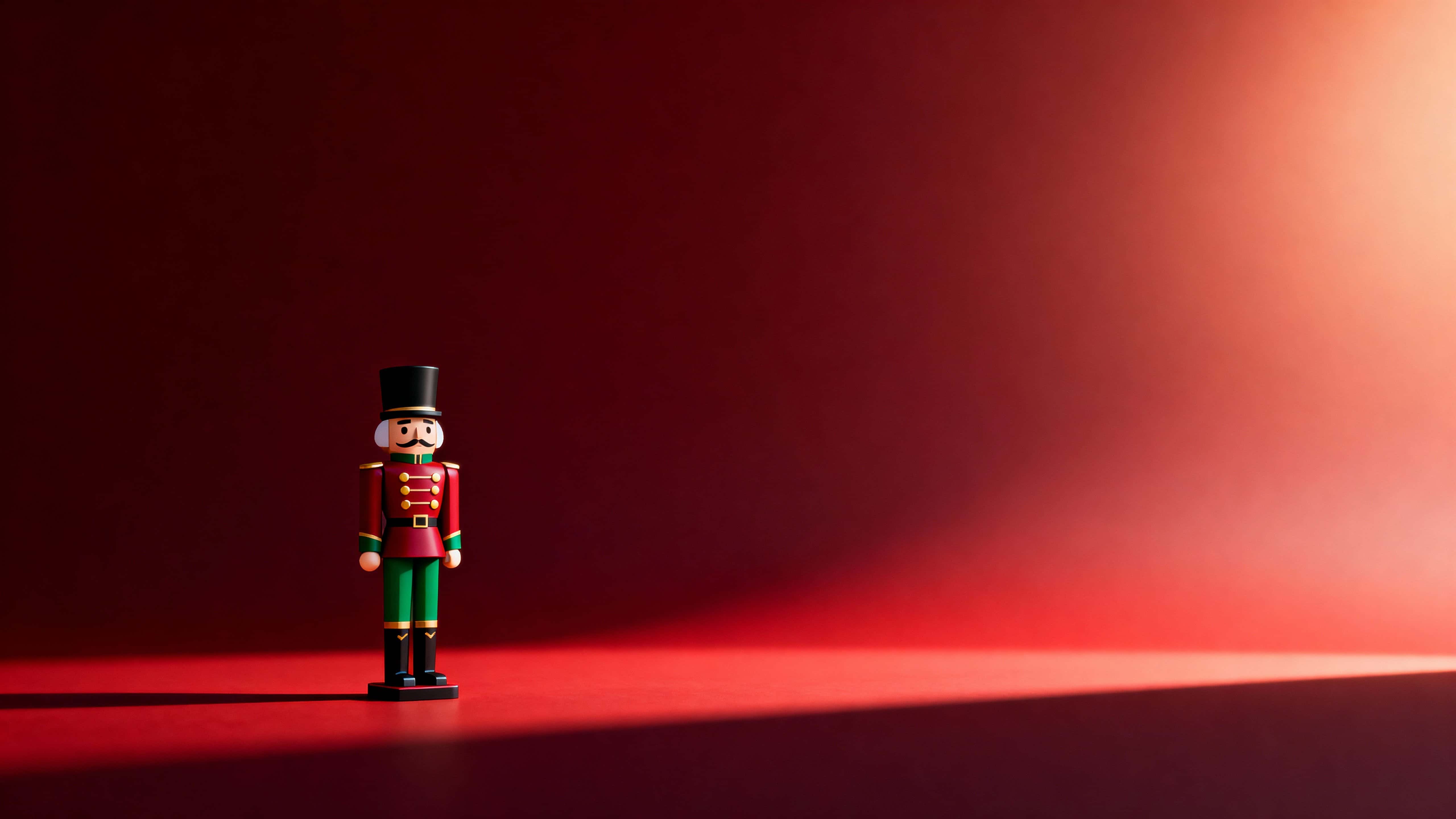 A wide 16:9 Christmas scene shows a single nutcracker figure on the left wearing a deep red uniform with green accents and gold buttons against a dark red gradient background.