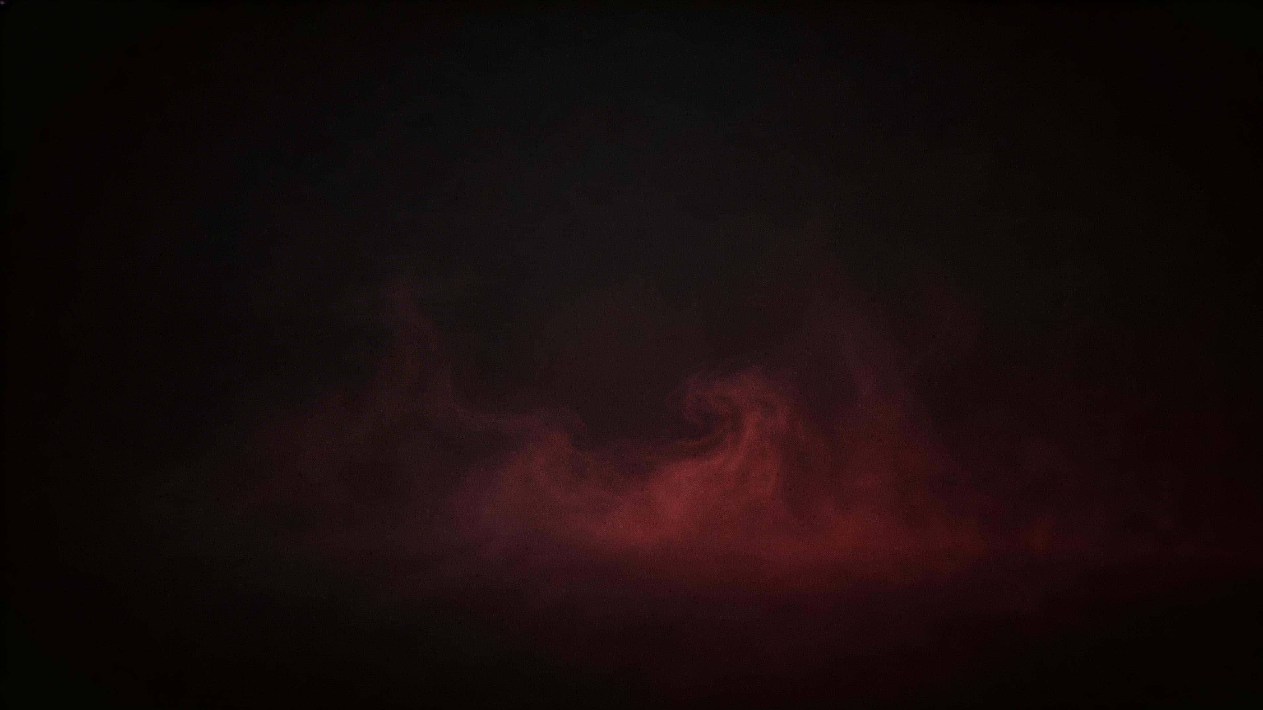 Cinematic 16:9 editorial photograph of low-density red gel-lit fog forming soft volumetric wisps against a near-black background, with calm negative space and a smooth vignette.
