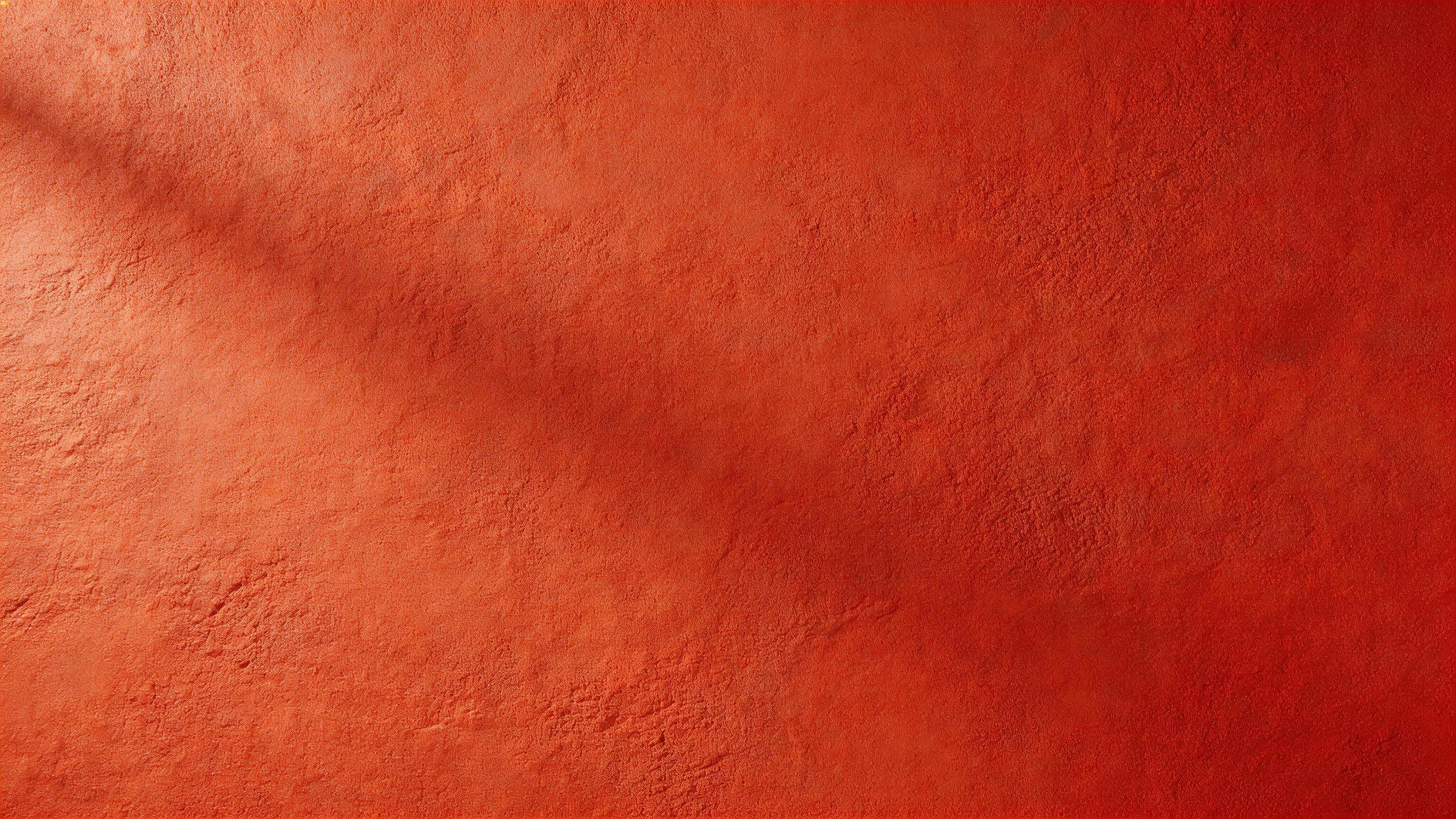 Widescreen 16:9 studio-style photograph of a minimal red plaster wall with subtle micro-variation and shallow relief, softly side-lit to reveal calm negative space.