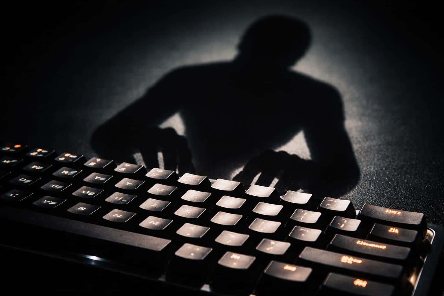 Moody 3:2 photographic poster of a human-shaped shadow typing on a backlit mechanical keyboard, with low-key contrast and crisp key textures for wallpaper.