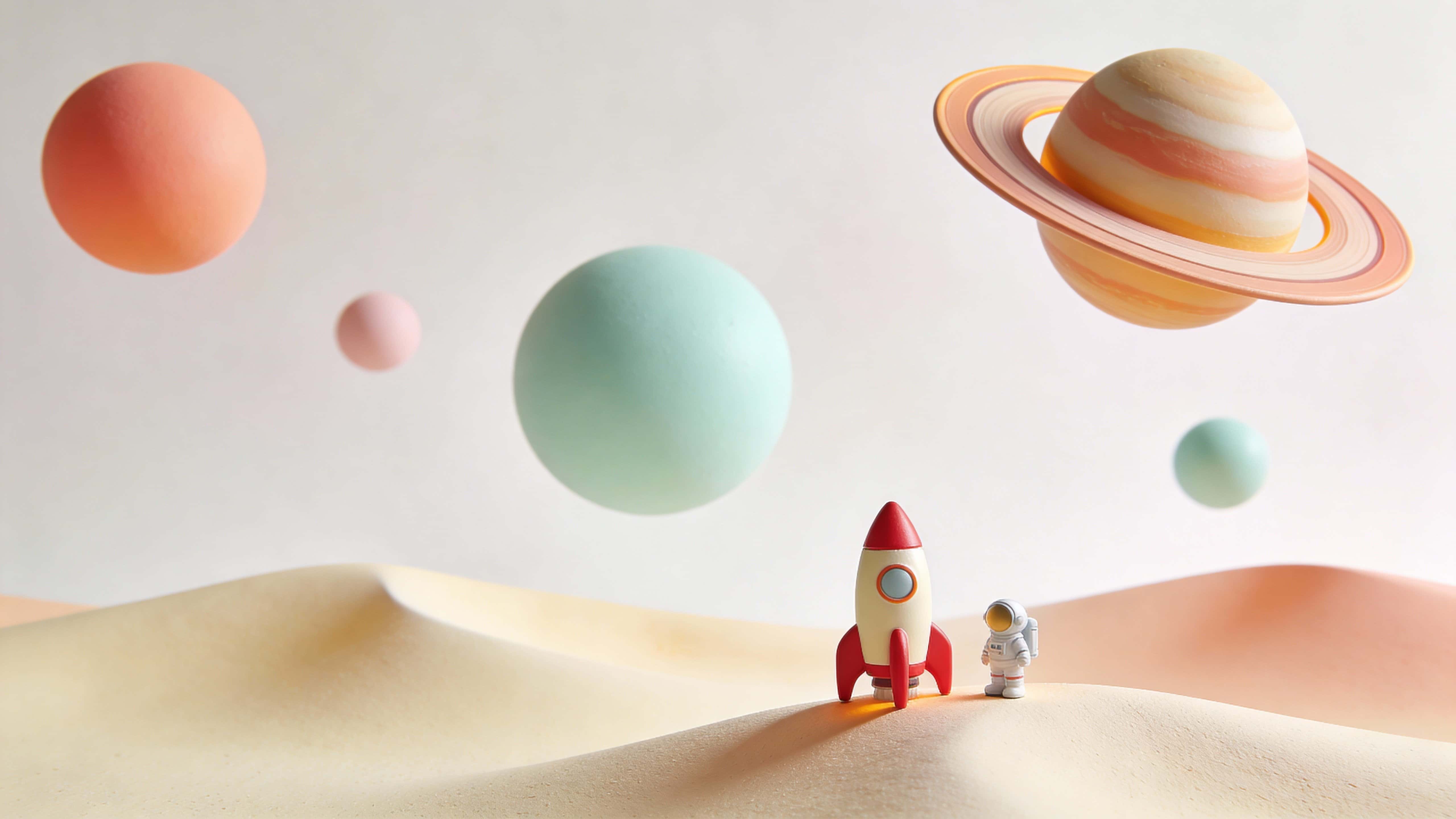 A small red-and-cream rocket beside a tiny astronaut stands on a pale sand dune in a 16:9 scene with soft pastel spheres and a ringed planet floating against a near-white sky.