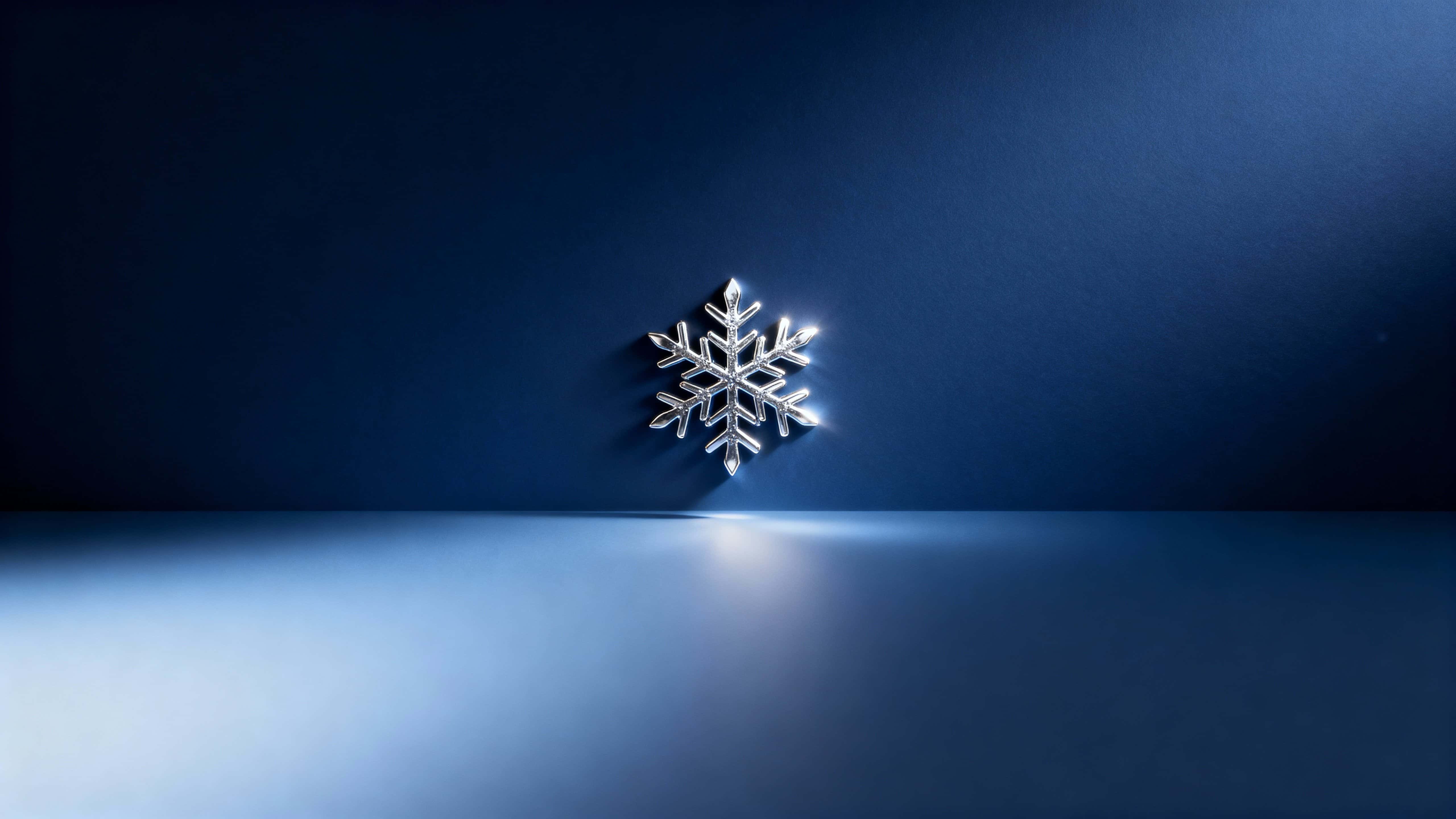 Minimalist 16:9 scene with one intricate metallic silver snowflake placed slightly above center on a deep midnight-blue gradient that darkens toward the corners, softly lit from lower-left with a faint edge glow and a clean lower-half copy‑